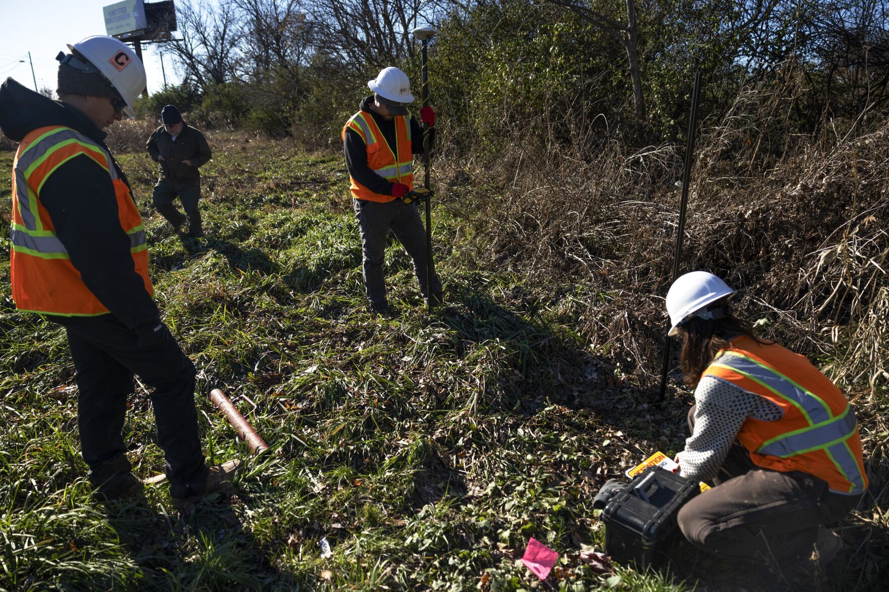 Contractors with the Army Corps of Engineers install signage along Coldwater Creek